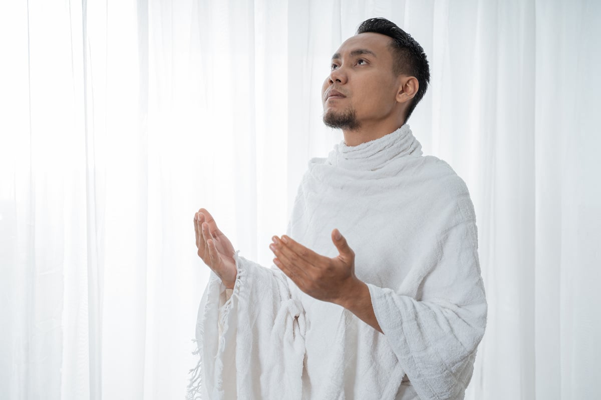 Muslim Man Praying in White Traditional Clothes